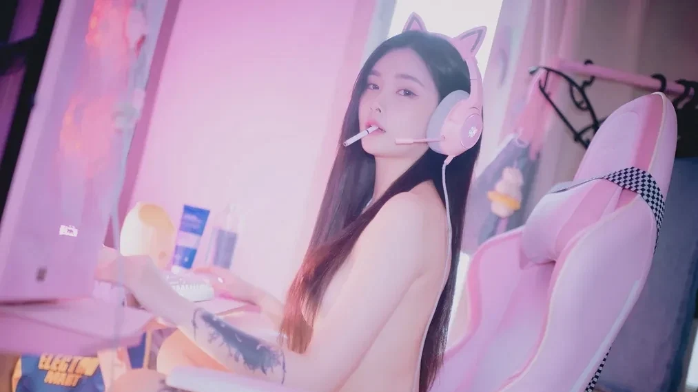 戴猫耳耳机的长发女子坐在粉色电竞椅前