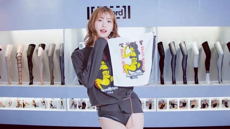 短发女子在陈列架前展示印有图案的上衣
